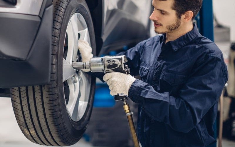 Mechanic in shop performing tire alignment 